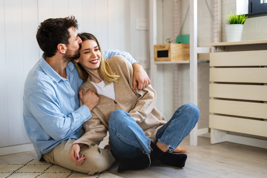 Happy and diverse couple sharing a joyful moment at home, embracing and smiling together