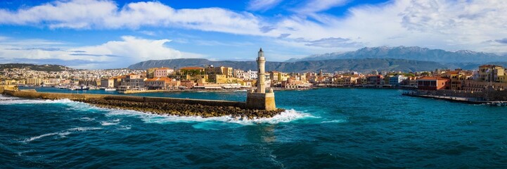 Obraz premium Chania Crete 18K Panorama, Old Venetian Port Aerial View with Ancient Lighthouse and Crushing Waves, Historic Harbor Architecture and Mediterranean Sea Background, Greece Travel High Res 8K 