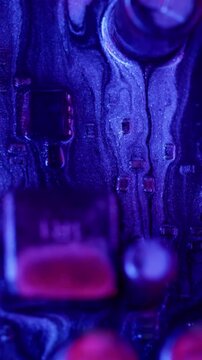Vertical video. Ink spill. Processor chip. Blur blue red pink color digital texture acrylic glitter liquid motherboard on abstract electronic art background.
