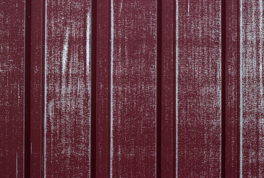 Red weathered corrugated metal background with scratch marks