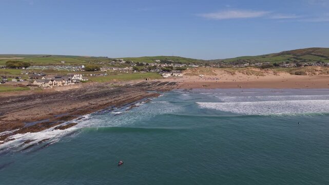 Aerial drone footage of Croyde Beach in North Devon, England, showcasing a sandy shoreline, rolling waves, and a popular surfing destination along the Atlantic coast