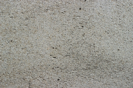 Grey grainy concrete wall texture. Seamless cement surface background.