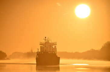 Obraz premium Schiffe bei Sonnenaufgang im Nord-Ostsee-Kanal 