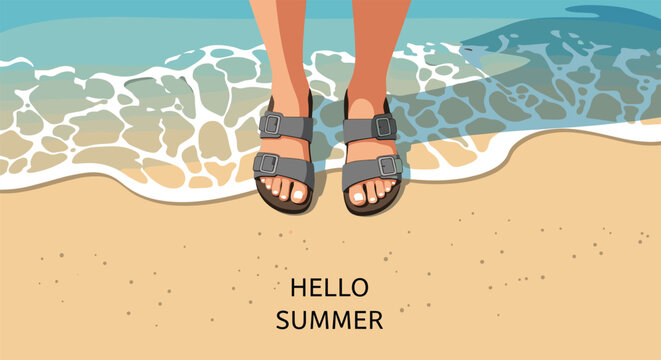 Top view of human feet wearing gray sandals standing on a sandy beach with ocean waves and hello summer text overlay.