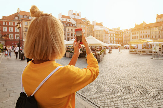 Travel in Warsaw, tourist woman with camera of Old town square, Warsaw, Poland