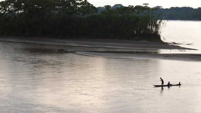 Canoe traveling on the Rio Napo in the Ecuadorian Amazon at dusk.Rio Napo is a major tributary of the Amazon. At Pompeya Sur, Orellana province, Ecuador. 