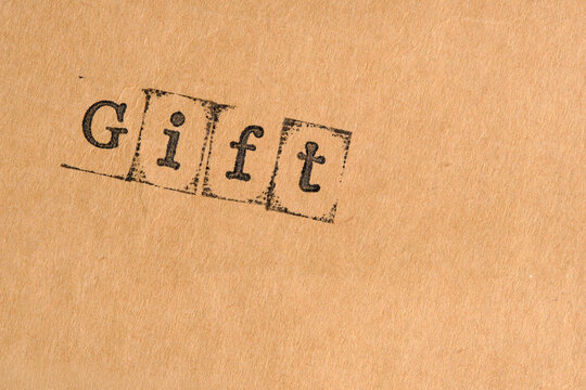 Gift text stamp angled on grainy vintage background with visible ink bleed and aged borders.