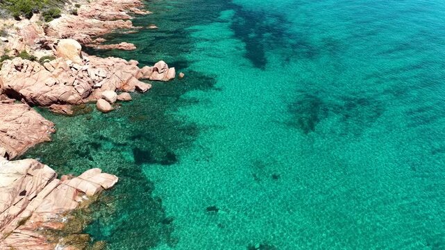 Aerial view of Su Sirboni Beach, Marina di Gairo, Sardinia, Italy. Turquoise sea, rugged red cliffs and hidden coves along the wild Ogliastra coastline