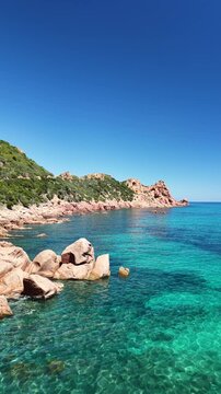 Aerial view of Su Sirboni Beach, Marina di Gairo, Sardinia, Italy. Turquoise sea, rugged red cliffs and hidden coves along the wild Ogliastra coastline