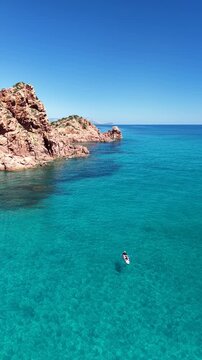 Aerial view of Su Sirboni Beach, Marina di Gairo, Sardinia, Italy. Turquoise sea, rugged red cliffs and hidden coves along the wild Ogliastra coastline