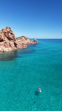 Aerial view of Su Sirboni Beach, Marina di Gairo, Sardinia, Italy. Turquoise sea, rugged red cliffs and hidden coves along the wild Ogliastra coastline