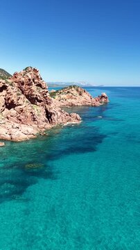 Aerial view of Su Sirboni Beach, Marina di Gairo, Sardinia, Italy. Turquoise sea, rugged red cliffs and hidden coves along the wild Ogliastra coastline