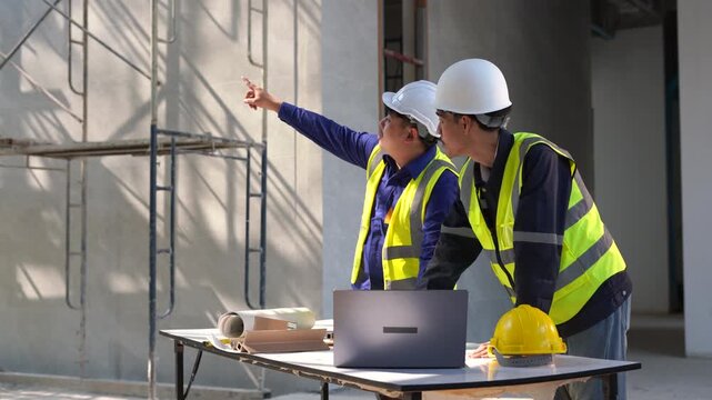 Engineers discuss project details at a construction site ensuring efficient collaboration for successful completion.