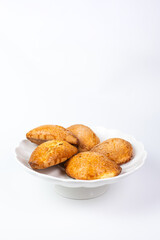 Fototapeta premium Golden cottage cheese pastries sochniki on a white decorative stand.