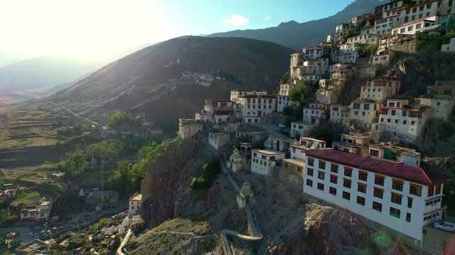 A Buddhist monastery with colorful roofs high in the mountains in the rays of the setting sun 