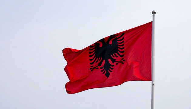 Flag of Albania Waving in the Blue Sky &ndash; Red Banner with Black Double-Headed Eagle Flowing in the Wind