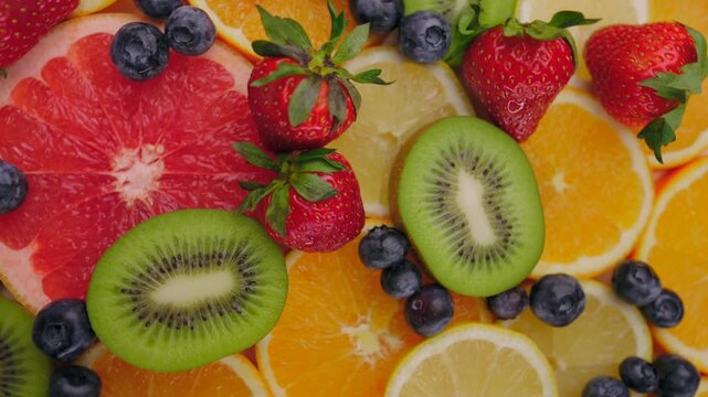 Background of fresh fruits and berries rotating. Vegan sweet food, flat lay.