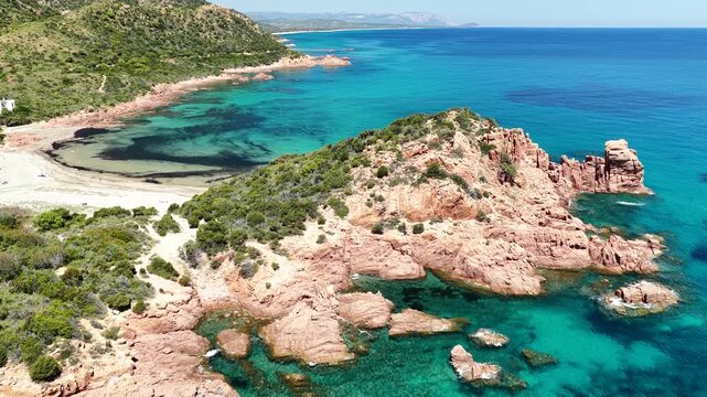 Aerial view of Su Sirboni Beach, Marina di Gairo, Sardinia, Italy. Turquoise sea, rugged red cliffs and hidden coves along the wild Ogliastra coastline