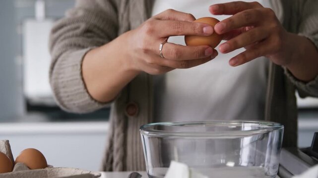 Woman picking egg from carton, cracking into bowl in kitchen with animated steps guiding recipe