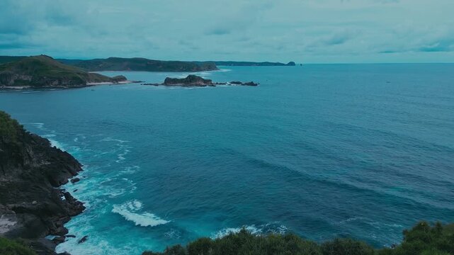 Aerial bukit merese hills coastline turquoise waters, dramatic drone sweep over grassy peninsula, limestone cliffs, secluded sandy coves, Bukit Merese, Lombok, Tanjung Ann, Indonesia