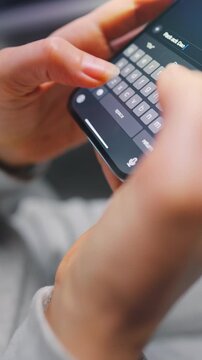 Female hands typing text on smartphone close-up.