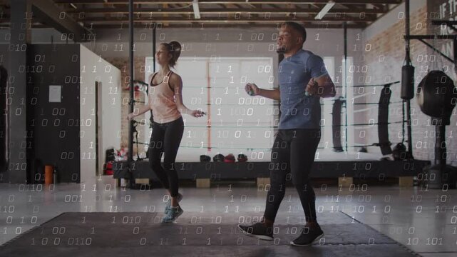 Man and woman holding ropes, synchronizing hops on gym mat for cardio, binary overlaying over duo