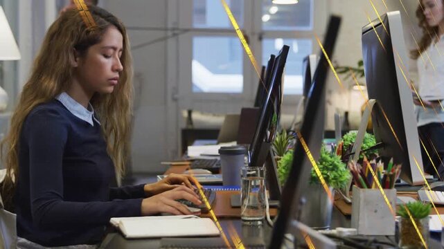 Office woman starting typing at keyboard, colleagues passing behind, completing business report