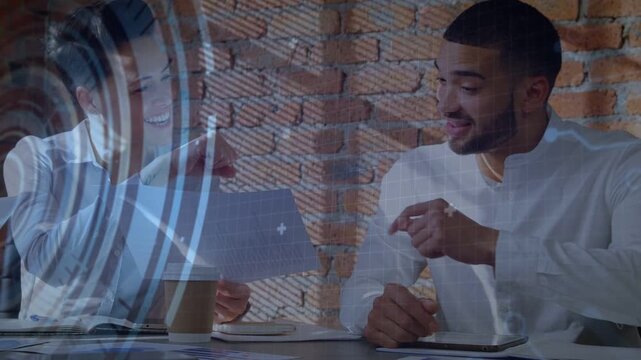 Left man holding paper up, right man looking, pointing and bumping, code HUD overlaying tech review