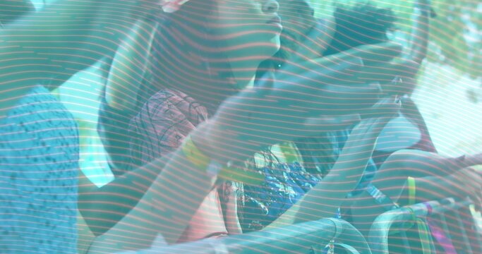 Leaning crowd pressing against metal barrier at outdoor fest showing wristbands and patterned tees