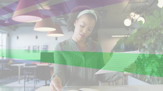 Woman lifting papers and checking notes at desk, business task, purple green bands hiding frames