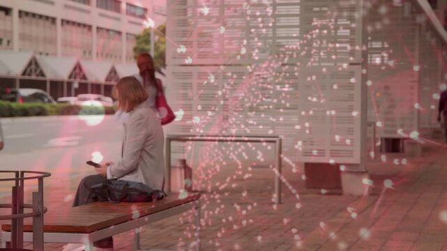 Woman using phone on transit bench, red overlay sweeping over crowd, causing standing to catch bus