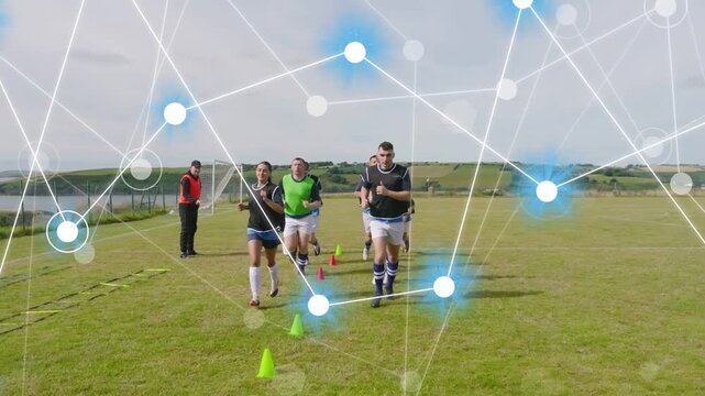 Coach gesturing, players training through cones, ladder toward lens on grass pitch nodes overlaying