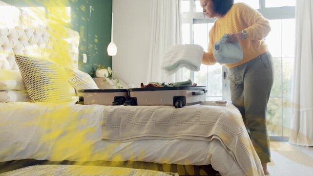 Entering from right, person grabbing blue toiletry bag, preparing suitcase for trip in bedroom