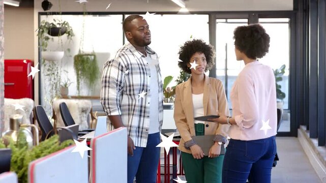 Three coworkers meeting in office, woman showing tablet sparking business review with star overlay