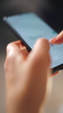 Female hands typing text on smartphone close-up.
