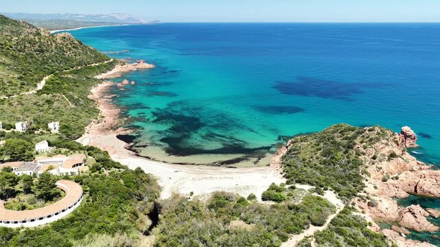 Aerial view of Su Sirboni Beach, Marina di Gairo, Sardinia, Italy. Turquoise sea, rugged red cliffs and hidden coves along the wild Ogliastra coastline