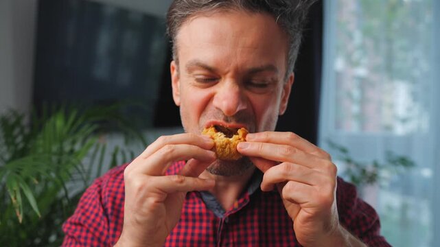 Junk food advertisement concept. Man eating fried chicken, enjoying fast food.