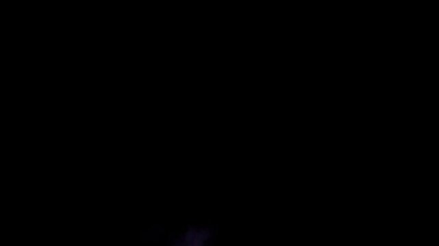 Lightning storm in the night sky featuring intense electrical bolts striking across the horizon and illuminating dark clouds during a heavy thunderstorm slow motion 240fps footage