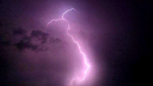 Lightning storm in the night sky Bolt of electricity flashing through dark purple clouds during a dramatic weather event slow motion 240fps footage