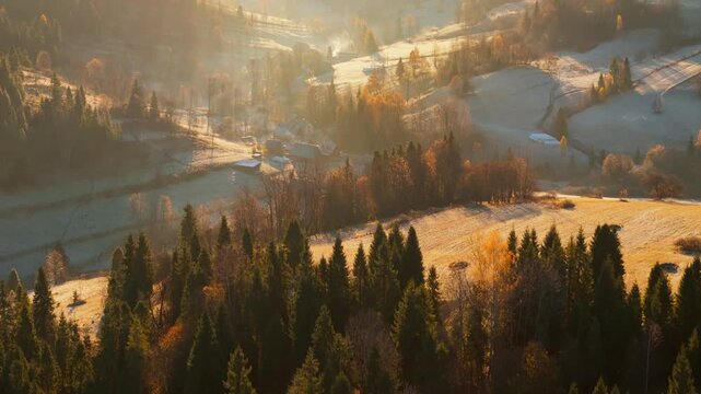Dawn in the mountains in autumn. Sun rays break through the morning fog.
