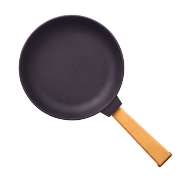 Levitating small cast iron frying pan with a wooden handle isolated on a white background. Minimalist zero gravity kitchen cookware.