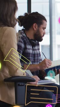 Vertical video: Man taking notes in blue notebook in office meeting while chat icons nudging glance