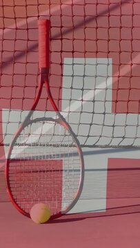 Vertical video: Racket entering frame, ball settling by net, cross backdrop framing sports shot