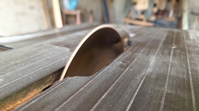 Circular saw blade spinning on a heavy-duty table saw inside a professional woodworking workshop High Quality Footage