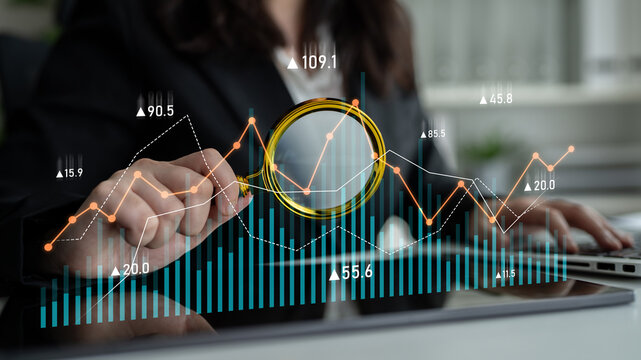 Business professional focuses on data analysis with financial graphs and charts, utilizing a magnifying glass for detailed insights and informed decision making. Scalp