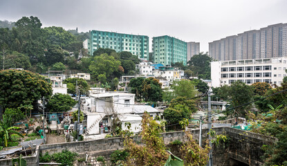 Obraz premium Aberdeen, Hong Kong : Brick Hill Squatter Area contrasts with surrounding high rise housing, illustrating urban density and social inequality