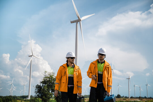 Professional Maintenance Crew Field Inspection Wind Mill Background, Walking Wind Turbine Maintenance Green Power Project. Future Electricity Grid Field Work. Renewable Power Generation Site