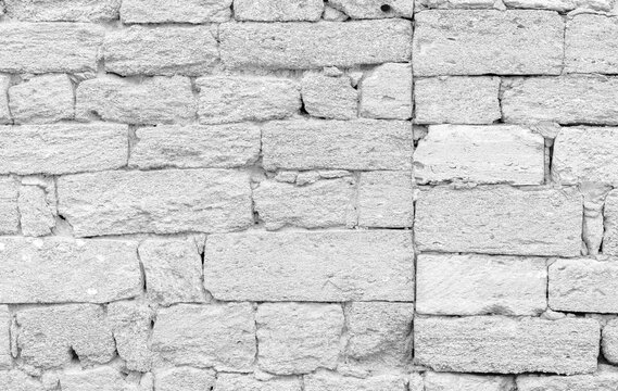 A textured shell rockwall made of irregular, weathered blocks in grayscale tones. This rugged exterior backdrop evokes historic masonry, rustic charm, and timeless architecture
