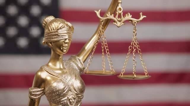 Golden Statue of Justice with American flag background