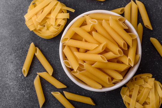 Italian uncooked dry penne regate pasta ready for cooking. Dry penne pasta